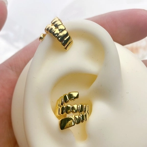 Detailed view of wide C-shaped and triple-layer spiral gold ear cuffs on ear model