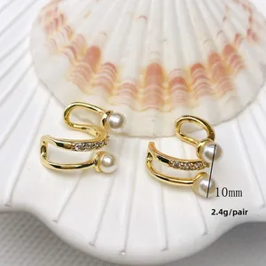 Close-up of double-layer C-shape gold ear cuffs with white pearls and sparkling zircons