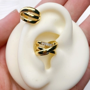 Macro detail of gold-plated multi-layer ear cuff with shimmering zircon stone inlays
