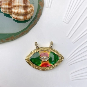 Macro view of gold-plated evil eye charm with colorful enamel and zircon stones