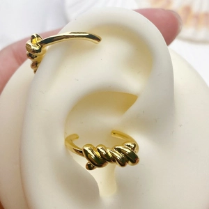 Detailed view of an 18K gold-plated twisted rope ear cuff on a mannequin model