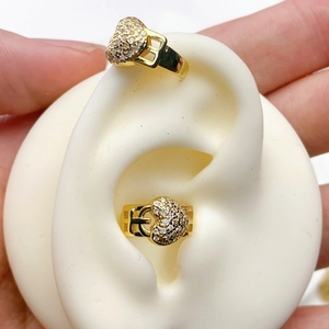 Detail of heart-shaped gold ear cuff encrusted with white zircon stones on model