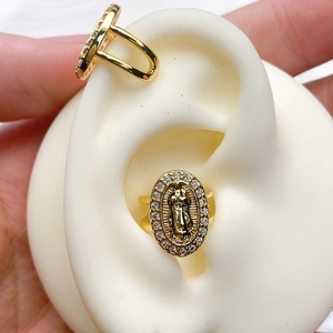 Close-up of gold U-shaped ear cuff with religious relief portrait and zirconia inlay