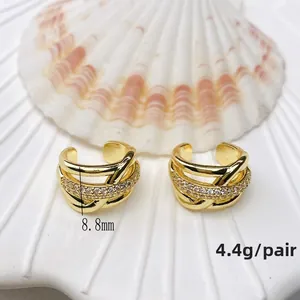 Macro shot of 8.8mm gold U-shaped ear cuffs with micro-inlaid white zircons on a shell