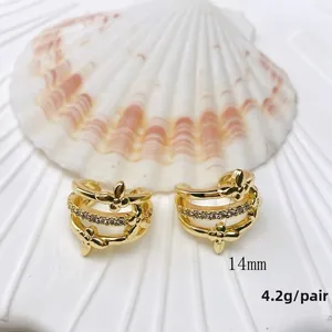 Detail view of 14mm gold layered ear cuffs featuring clover design with zircon inlays