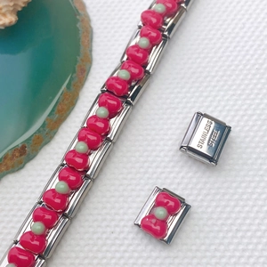 Nahaufnahme eines italienischen Edelstahl-Armbands mit roten Kirschen und grünen Details