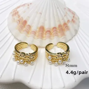 Detail of 18K gold plated C-shaped earrings with pearls on white shell background, weight 4.4g