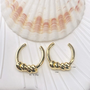 Detail view of 18K gold plated twisted earrings with measurements on shell background