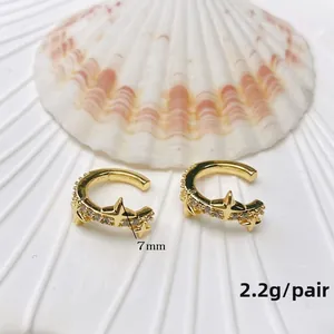 Detail view of gold U-shaped ear cuffs with star design and zircon pave, 7mm size