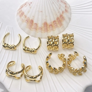 Set of four 18K gold plated wavy geometric ear cuffs shown on a white shell tray