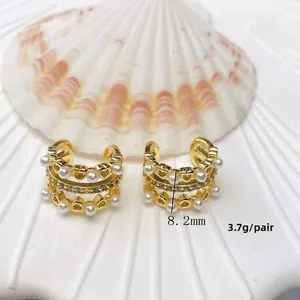Detail view of gold heart ear cuffs with pearls and size labels showing 8.2mm height
