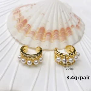 Detail view of U-shaped gold ear cuff with white pearls and sparkling zircons