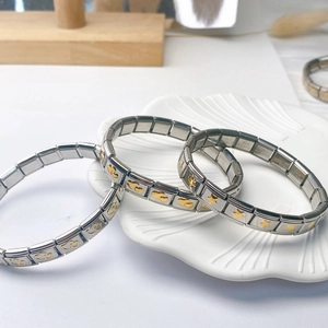 Détail de trois bracelets modulables en acier inoxydable avec breloques étoile et cœur