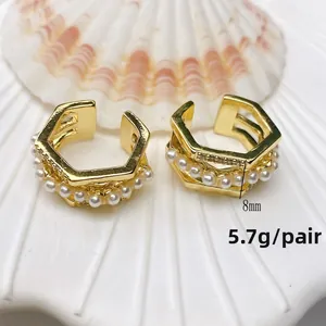 Detail view of gold U-shaped ear cuffs with pearls and crystals on white shell, 5.7g pair