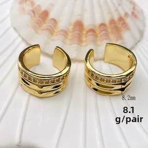 Detail view of gold wave ear cuffs with white zircon inlay on shell, 8.2mm wide