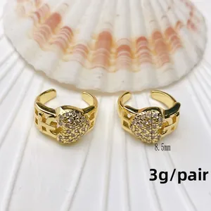 Detail shot of U-shaped gold heart ear clips with tiny zircon studs and shell decor