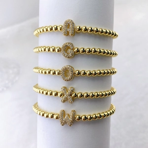 Set de pulseras doradas con dijes de letras iniciales y circonitas micro-pavé