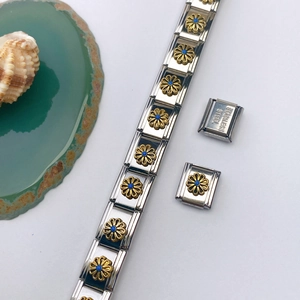 Détail d'un maillon de bracelet en acier inoxydable avec une fleur de marguerite dorée