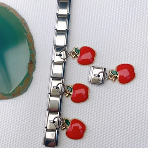 Détail du bracelet modulaire italien avec un pendentif pomme rouge en émail brillant