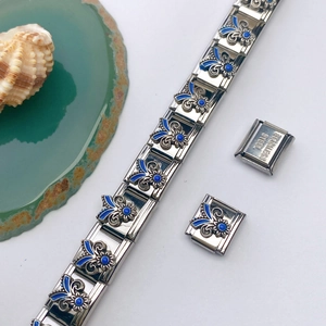 Vue détaillée du bracelet italien avec fleur en émail bleu et poinçon en acier inoxydable