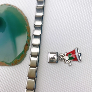 Gros plan du bracelet à breloques italien en inox avec un pendentif cloche de Noël