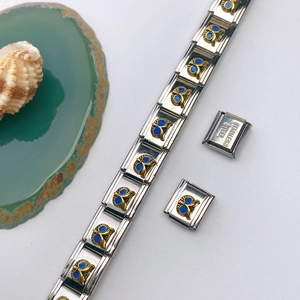 Détail du maillon de bracelet en acier inoxydable avec papillon doré et émail bleu