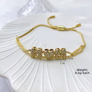 Detail of adjustable gold MOM bracelet with zircon stones and shell tray background