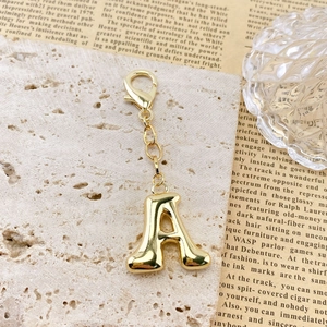 Détail macro du porte-clés doré lettre A en 3D avec une finition miroir brillante