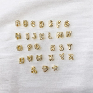 Detailed view of 26 alphabet balloon pendants paved with sparkling cubic zirconia stones