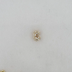 Macro shot of gold-plated letter C pendant with shimmering pavé zircon stones