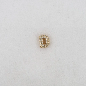Macro shot of gold letter D pendant with sparkling zircon stones for DIY bracelets