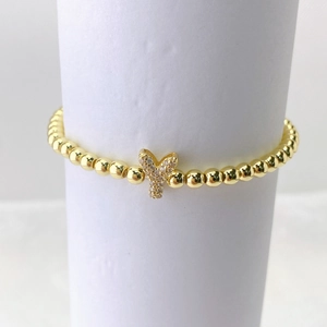 Primer plano de pulsera dorada con colgante de mariposa en micro pavé de circonitas