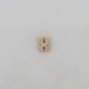 Close-up of golden letter H pendant featuring a sparkling pave-set cubic zirconia design