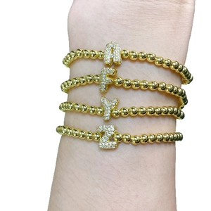 Set de cuatro pulseras de cuentas doradas con colgantes de letras A F Y Z en circonita