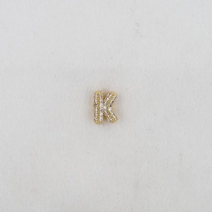 Detailed view of bubble initial K pendant in gold finish with sparkling zircon stones