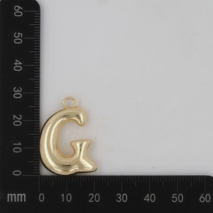 Vue détaillée du pendentif lettre G dorée avec dimensions affichées sur une règle graduée