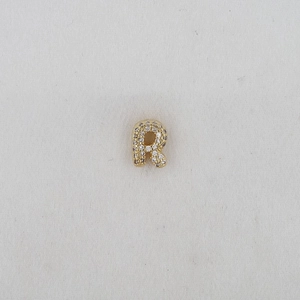 Detailed macro view of gold-plated balloon letter R pendant with cubic zirconia inlay