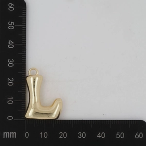 Vue macro du pendentif lettre L dorée montrant une taille de 25 mm sur une règle