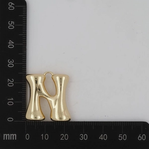 Vue détaillée du pendentif lettre N dorée bombée avec échelle de mesure de 25mm de haut