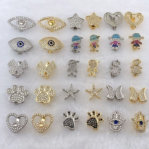 Detail view of 30-piece stainless steel bracelet charms featuring eyes stars and hearts