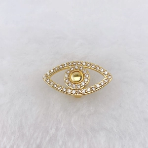 Macro detail of gold-plated evil eye charm with sparkling cubic zirconia on white fur