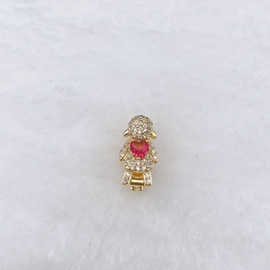 Detailed close-up of a golden girl charm with pink heart gemstone and sparkling zirconias