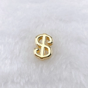 Vue détaillée d'un pendentif signe dollar doré avec finition métallique polie sur peluche