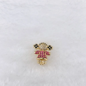 Detailed close-up of a girl-shaped charm with pink and white cubic zirconia on gold base