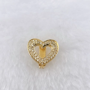 Close-up of golden heart-shaped clip accessory featuring sparkling pavé zircon stones