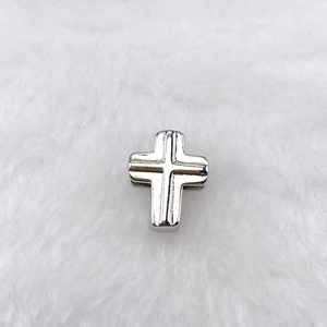 Pendentif croix en métal argenté poli avec détails rainurés sur fond en fausse fourrure