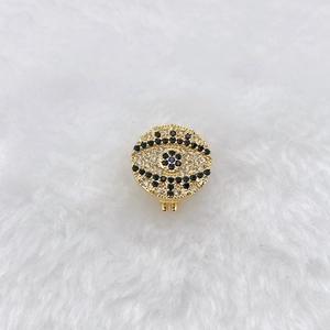 Detailed macro view of the gold-plated evil eye charm with black and white crystals
