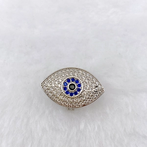 Detailed macro view of an intricate evil eye charm with blue zircon and silver base
