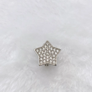 Close-up of star-shaped silver charm with pavé cubic zirconia on soft white fur
