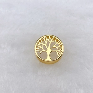 Gros plan d'un pendentif Arbre de Vie doré sur un fond de texture blanche douce
